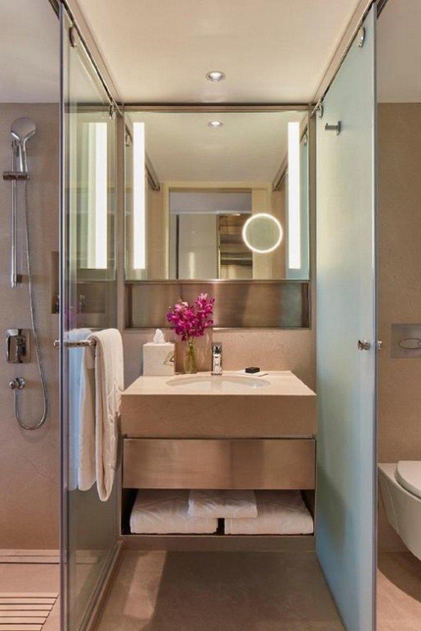 The Taj Mahal Tower, Mumbai Hotel Ngoại thất bức ảnh The photo shows a modern bathroom. It features a sleek, minimalistic design with a light-colored sink unit that includes a smooth countertop. On the countertop, there is a vase with purple flowers and a few toiletries. A large mirror with integrated 
