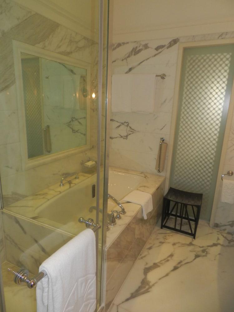 The Taj Mahal Tower, Mumbai Hotel Ngoại thất bức ảnh The photo displays a bathroom featuring a luxurious design. There is a glass-enclosed shower area alongside a large bathtub. The walls are adorned with marble, giving a sophisticated look. A few white towels are neatly arranged, and there is a small 