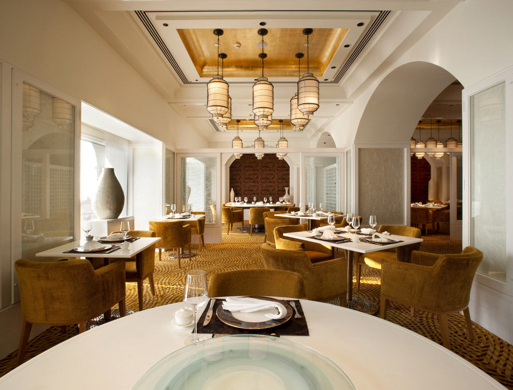 The Taj Mahal Tower, Mumbai Hotel Ngoại thất bức ảnh The photo shows an elegantly designed restaurant interior. The space features stylish furnishings, including round tables topped with white tablecloths and plush, mustard-colored chairs. The ceiling has a decorative design, with pendant lights hangin