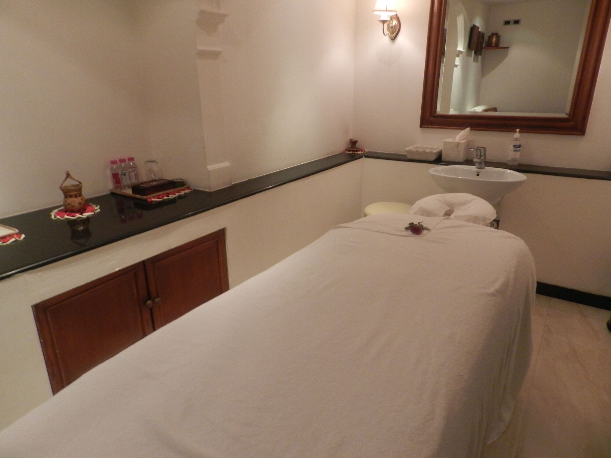 The Taj Mahal Tower, Mumbai Hotel Ngoại thất bức ảnh The photo shows a serene spa room designed for relaxation and treatments. In the center, there is a massage table covered with a white sheet. There is a small decorative item, possibly a flower, placed on the table. Alongside, a dark countertop displ